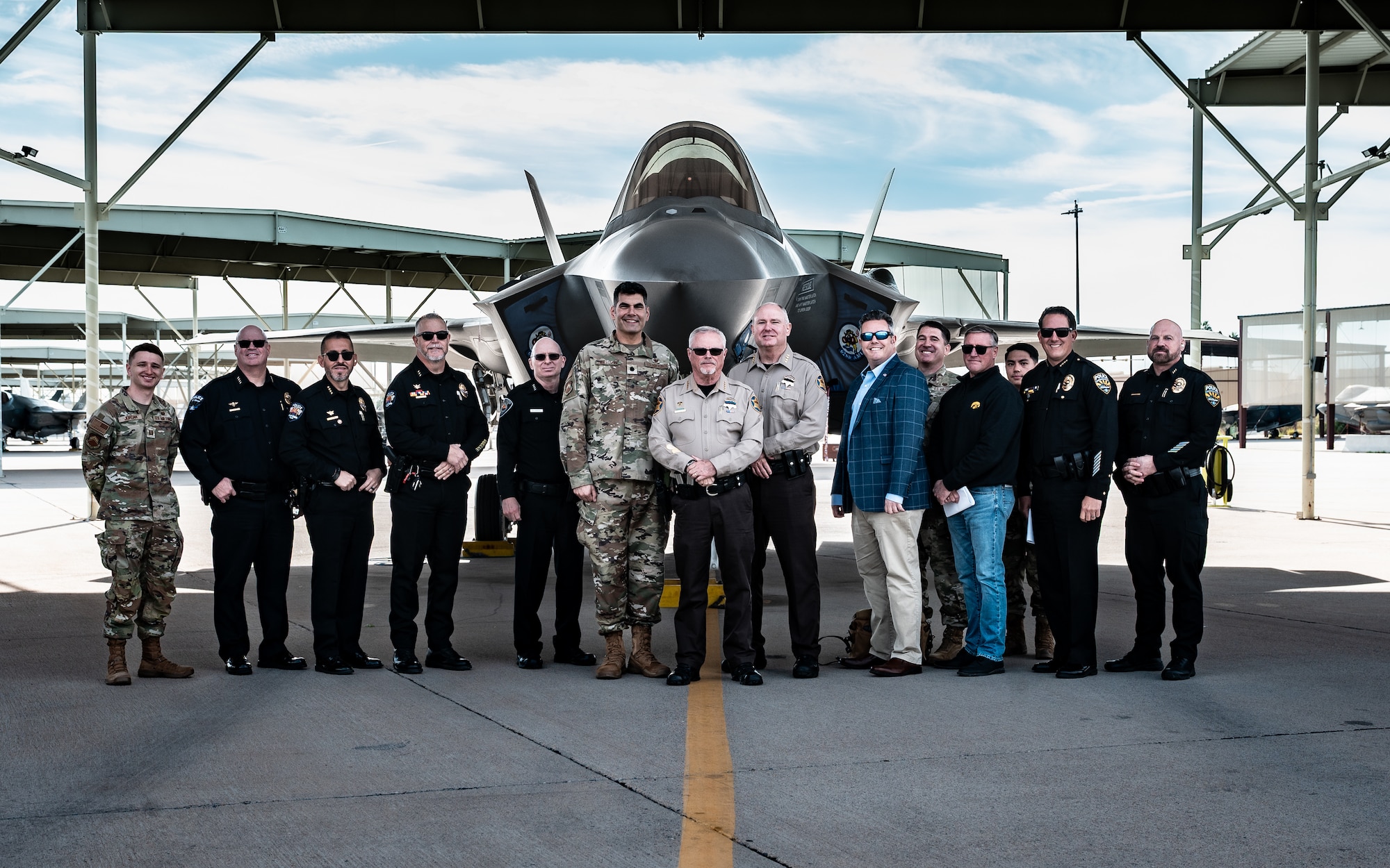 A delegation of local Police Chiefs poses in front of an F-35A Lightning II