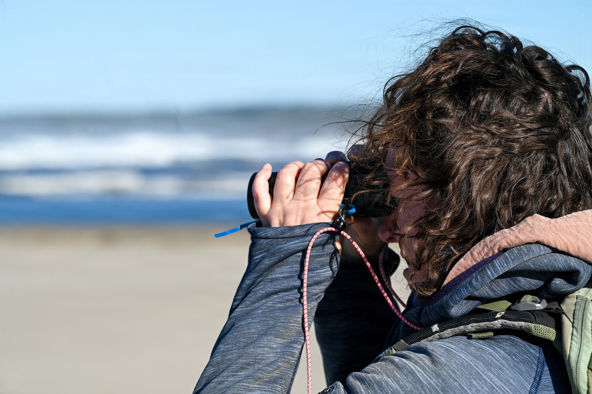 Emily Rice, Coastal Program Biologist of Point Blue Conservation Science, looks through her binoculars during a Western Snowy Plover winter survey.