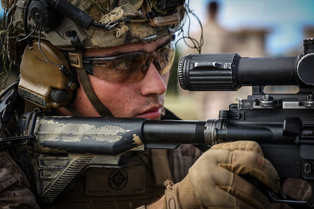 A U.S. Marine with Kilo Company, Battalion Landing Team 3/6, 22nd Marine Expeditionary Unit (Special Operations Capable), sights in on a target with their M27 infantry automatic rifle during a long bay range on Camp Santiago, Puerto Rico.
