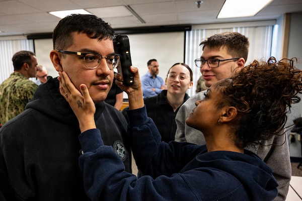 Hospital Corpsman 3rd Class Rachel Leyva, right, operates a near infrared Traumatic Brain Injury assessment device during an end-user touchpoint hosted by the Operational Medical Systems Program Management Office, Camp Lejeune, North Carolina, Jan. 14, 2026. Leyva, originally from Houston, Texas, is assigned to the Naval Medical Center Camp Lejeune. The touchpoint at NMCCL is one in a series of planned engagements with prospective end users to help the OPMED Warfighter Readiness, Performance and Brain Health project management office refine the development of field-portable TBI detection devices designed for use in austere, remote locations across the globe. OPMED, part of the Defense Health Agency, partners with stakeholders across the Joint Force to develop, acquire, and field medical devices, treatments, and frontline care solutions for military medical providers to fill capability gaps with the speed of relevance. (Defense Health Agency photo by T. T. Parish/Released)