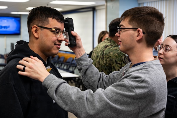 Hospital Corpsman Xander Jacobson, right, operates a near infrared Traumatic Brain Injury assessment device during an end-user touchpoint hosted by the Operational Medical Systems Program Management Office, Camp Lejeune, North Carolina, Jan. 14, 2026. Jacobson, originally from Cherry Point, North Carolina, is assigned to the labor and delivery unit at Naval Medical Center Camp Lejeune. The touchpoint at NMCCL is one in a series of planned engagements with prospective end users to help the OPMED Warfighter Readiness, Performance and Brain Health project management office refine the development of field-portable TBI detection devices designed for use in austere, remote locations across the globe. OPMED, part of the Defense Health Agency, partners with stakeholders across the Joint Force to develop, acquire, and field medical devices, treatments, and frontline care solutions for military medical providers to fill capability gaps with the speed of relevance. (Defense Health Agency photo by T. T. Parish/Released)