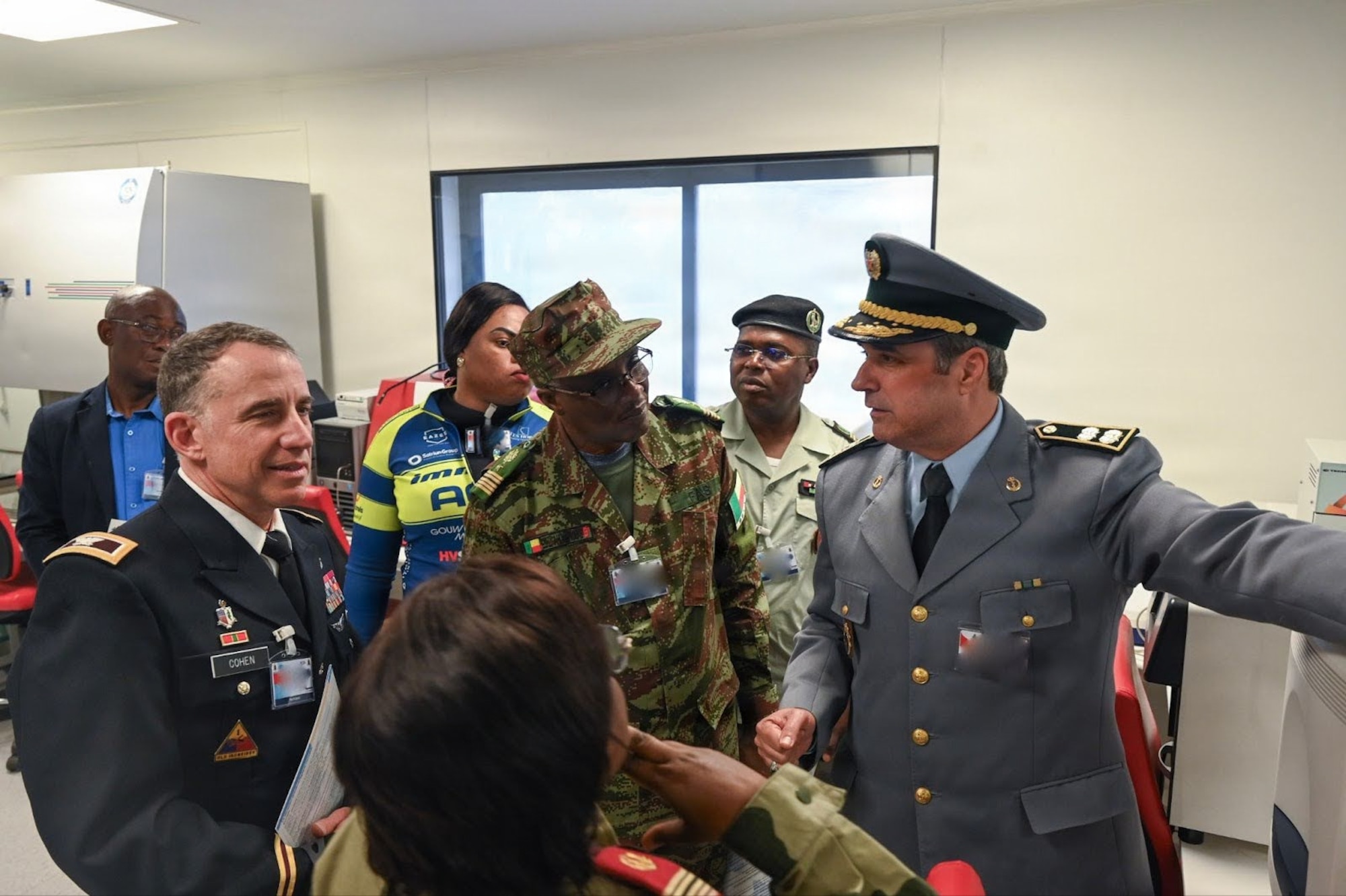 U.S. Army Col. Michael Cohen, U.S. Africa Command command surgeon, far left, receives a briefing along with other the African Partner Outbreak Response Alliance 2025 Workshop attendees from Moroccan Armed Forces Col. Idriss Lahlou Amine, Mohammed V Military Training Hospital virology laboratory chief, far right, during a hospital tour in Rabat, Morocco, Dec. 10, 2025. Members attending the APORA 2025 Workshop received a tour of the hospital to see first-hand how the Moroccan Armed Forces respond and treat infectious diseases. (U.S. Air Force photo by Capt. Benjamin Aronson) (This photo was altered for security purposes by blurring security badges.)