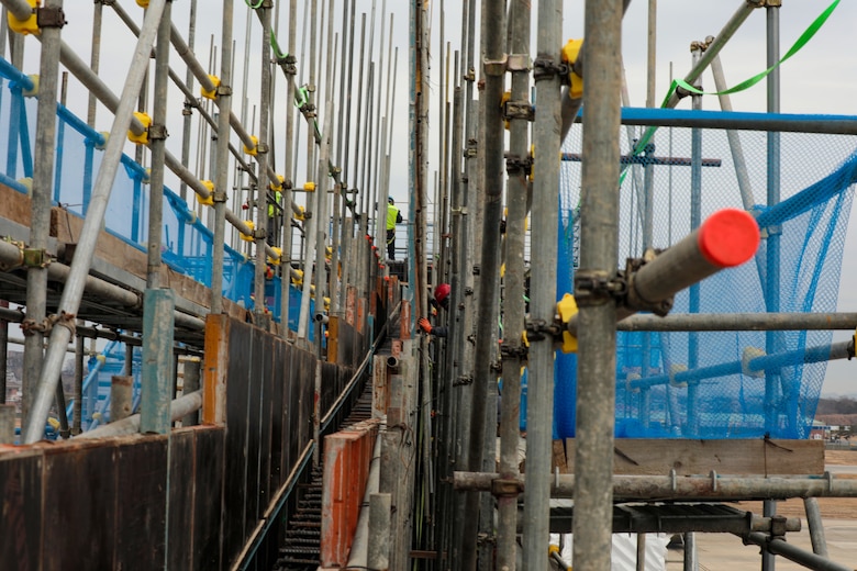 Contractor installing scaffolding at project site.