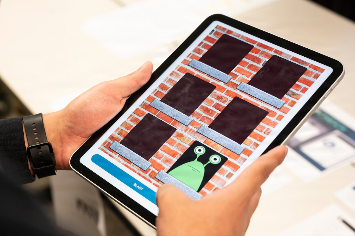 A close-up of a person playing a memorization game on a tablet.