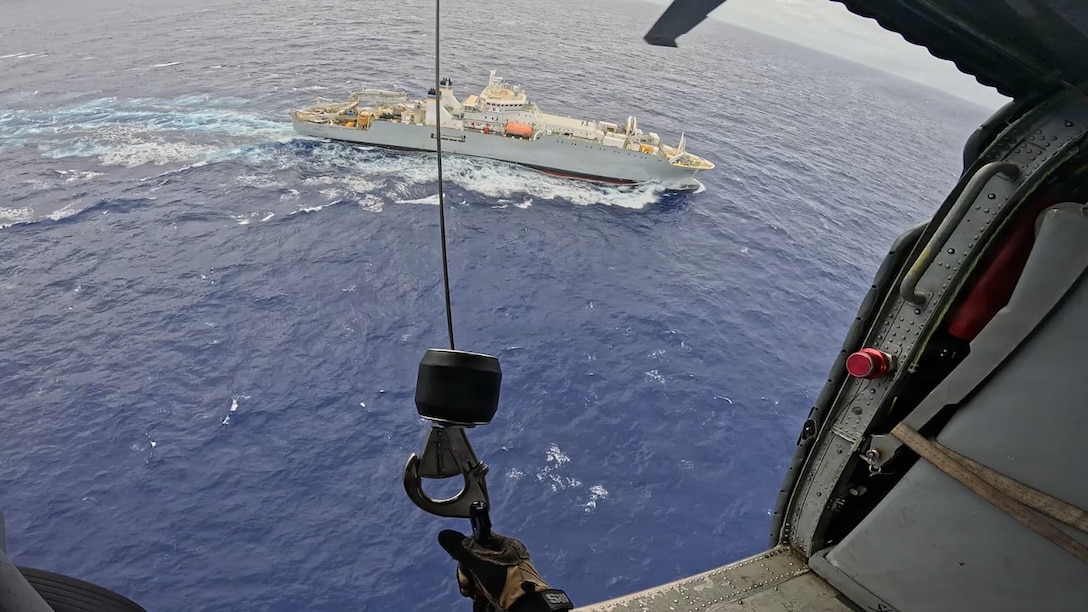 A U.S. Navy MH-60 Knighthawk helicopter crew from Helicopter Sea Combat Squadron 25 approaches the 459-foot U.S.-flagged cable-laying ship Decisive on Jan. 13, 2026, about 110 miles off Guam to medically evacuate an ill 60-year-old mariner to Guam for a high level of medical care. U.S. Coast Guard Joint Rescue Sub-Center Guam watchstanders received the medical evacuation request from the captain of the Decisive at approximately 10:10 a.m. local time on Jan. 12 while the ship was over 400 nautical miles offshore of Guam, outside of hoist-capable aircraft range, and worked to coordinate the medevac. (U.S. Navy photo by HSC-25)