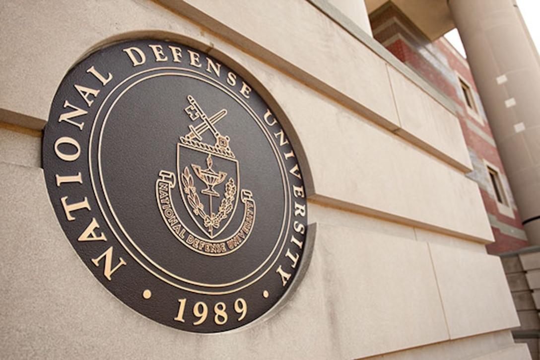 The National Defense's University seal on the side of a building