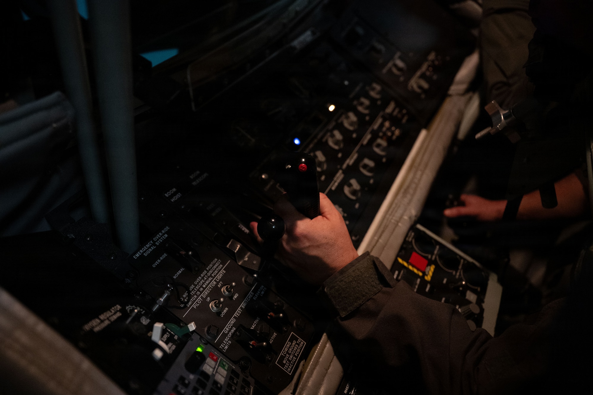 A hand grabs a boom operation throttle in a simulator. 