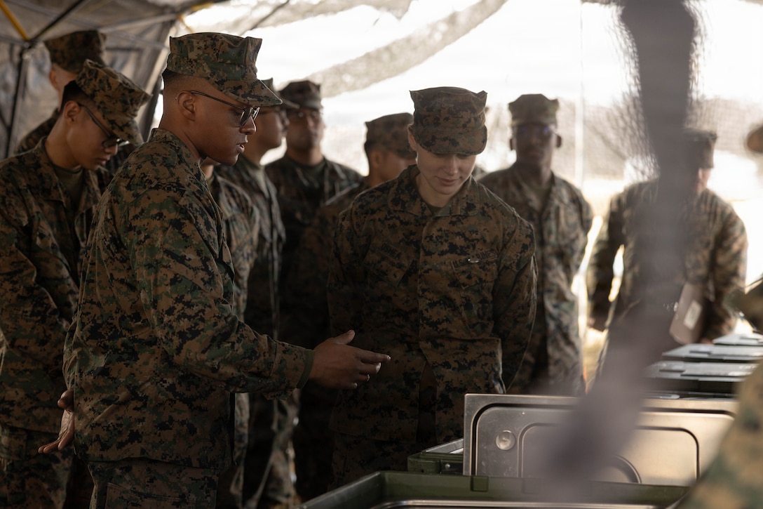 U.S. Marine Corps Lance Cpl. Bryce Frink (left) presents his prepared meal to Marines during a food service competition at Marine Wing Support Squadron (MWSS) 472, Wyoming, Pennsylvania, Jan. 11, 2026. Frink is a food service specialist with MWSS 472, Marine Aircraft Group 49, 4th Marine Aircraft Wing. Marines participated in an inspection for the Maj. Gen. William Pendleton Thompson Hill Awards to demonstrate their quality of food preparation, sanitation, and customer service. (U.S. Marine Corps photo by Lance Cpl. Priscilla Flores)
