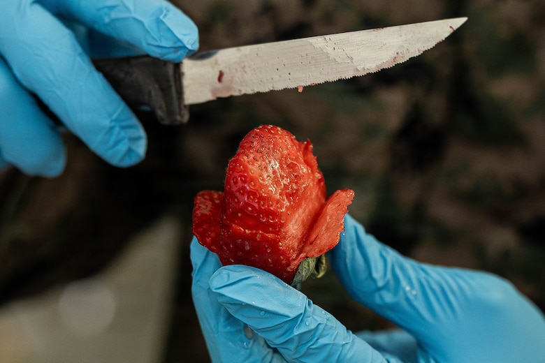 U.S. Marine Corps Cpl. Oscar Elias slices a strawberry during a food service competition at Marine Wing Support Squadron (MWSS) 472, Wyoming, Pennsylvania, Jan. 11, 2026. Elias is a food service specialist with MWSS 472, Marine Aircraft Group 49, 4th Marine Aircraft Wing. Marines participated in an inspection for the Maj. Gen. William Pendleton Thompson Hill Awards to demonstrate their quality of food preparation, sanitation, and customer service. (U.S. Marine Corps photo by Lance Cpl. Priscilla Flores)