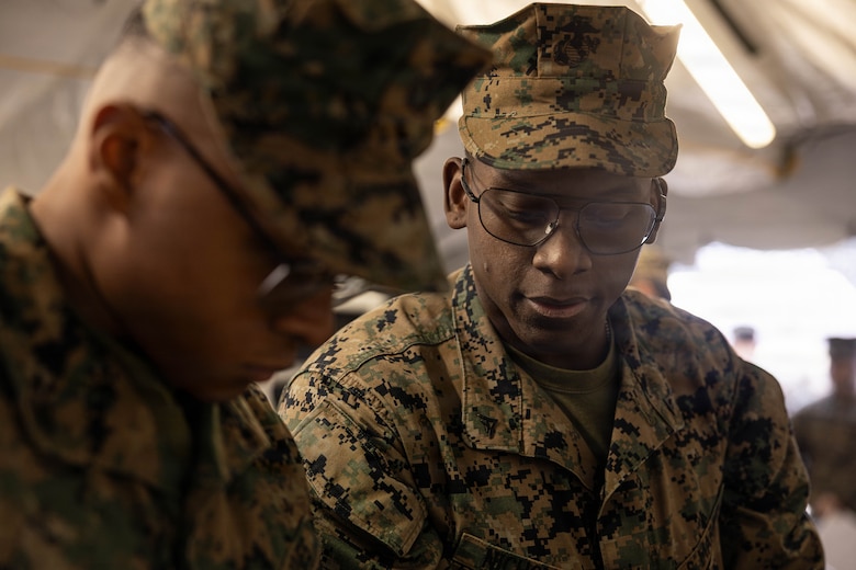 U.S. Marine Corps Lance Cpl. Bryce Frink (left) and Lance Cpl. Jahnari Nicholas (right) prepare food during a food service competition at Marine Wing Support Squadron (MWSS) 472, Wyoming, Pennsylvania, Jan. 11, 2026. Frink and Nicholas are both food service specialists with MWSS 472, Marine Aircraft Group 49, 4th Marine Aircraft Wing. Marines participated in an inspection for the Maj. Gen. William Pendleton Thompson Hill Awards to demonstrate their quality of food preparation, sanitation, and customer service. (U.S. Marine Corps photo by Lance Cpl. Priscilla Flores)