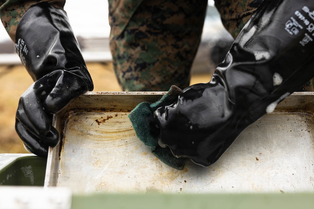 U.S. Marine Corps Cpl. Gunnar Wenzl washes a baking tray during a food service competition at Marine Wing Support Squadron (MWSS) 472, Wyoming, Pennsylvania, Jan. 11, 2026. Wenzl is a logistics specialist with MWSS 472, Marine Aircraft Group 49, 4th Marine Aircraft Wing. Marines participated in an inspection for the Maj. Gen. William Pendleton Thompson Hill Awards to demonstrate their quality of food preparation, sanitation, and customer service. (U.S. Marine Corps photo by Lance Cpl. Priscilla Flores)