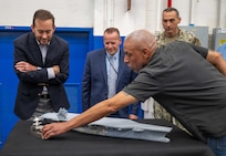 Mr. Alexis Colon, an employee with the Fabrication and Technical Support Division, explains to visitors how the team's equipment is able to deliver meticulous detail when assembling models for the U.S. Navy at Naval Surface Warfare Center, Carderock Division in West Bethesda on Aug. 28, 2025. Pictured from left are: Mr. Chris Miller, Executive Director of Naval Sea Systems Command; Mr. Tom Perotti, Executive Director, Naval Sea Systems Command, Engineering and Logistics (SEA 05), and (Acting) Executive Director Naval Surface and Undersea Warfare Centers; and Capt. Chris Matassa, Carderock's Commanding Officer.
