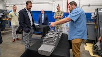 Mr. Adam Smith (right), an employee with the Fabrication and Technical Support Division, explains the assembly of the physical models to visitors at Naval Surface Warfare Center, Carderock Division in West Bethesda on Aug. 28, 2025. Pictured from left are: Mr. Matt Gutmann; Mr. Chris Miller, Executive Director of Naval Sea Systems Command; Mr. Tom Perotti, Executive Director, Naval Sea Systems Command, Engineering and Logistics (SEA 05), and (Acting) Executive Director Naval Surface and Undersea Warfare Centers; and Capt. Chris Matassa, Carderock's Commanding Officer.