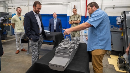 Mr. Adam Smith (right), an employee with the Fabrication and Technical Support Division, explains the assembly of the physical models to visitors at Naval Surface Warfare Center, Carderock Division in West Bethesda on Aug. 28, 2025. Pictured from left are: Mr. Matt Gutmann; Mr. Chris Miller, Executive Director of Naval Sea Systems Command; Mr. Tom Perotti, Executive Director, Naval Sea Systems Command, Engineering and Logistics (SEA 05), and (Acting) Executive Director Naval Surface and Undersea Warfare Centers; and Capt. Chris Matassa, Carderock's Commanding Officer.