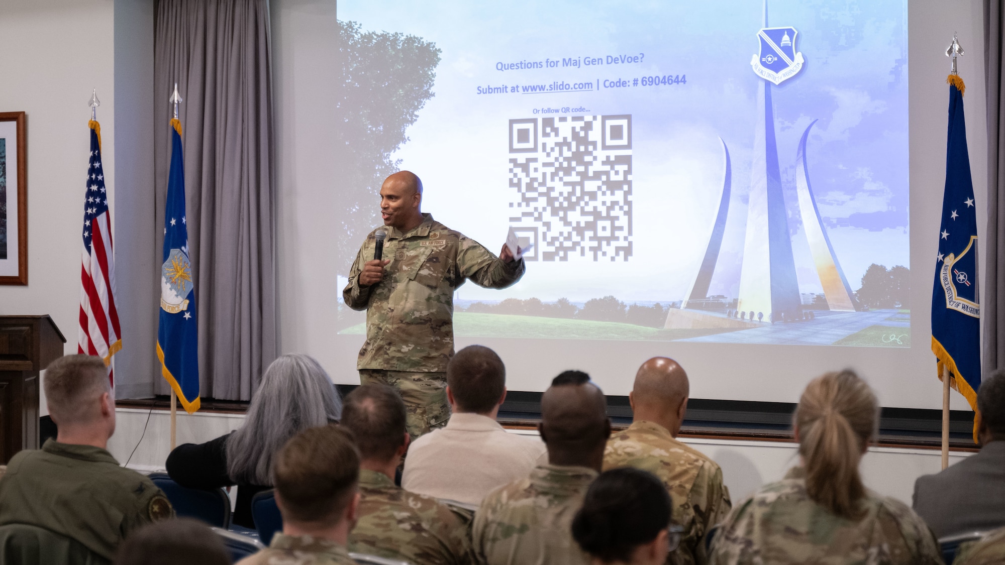 A man speaks in front of a crowd.