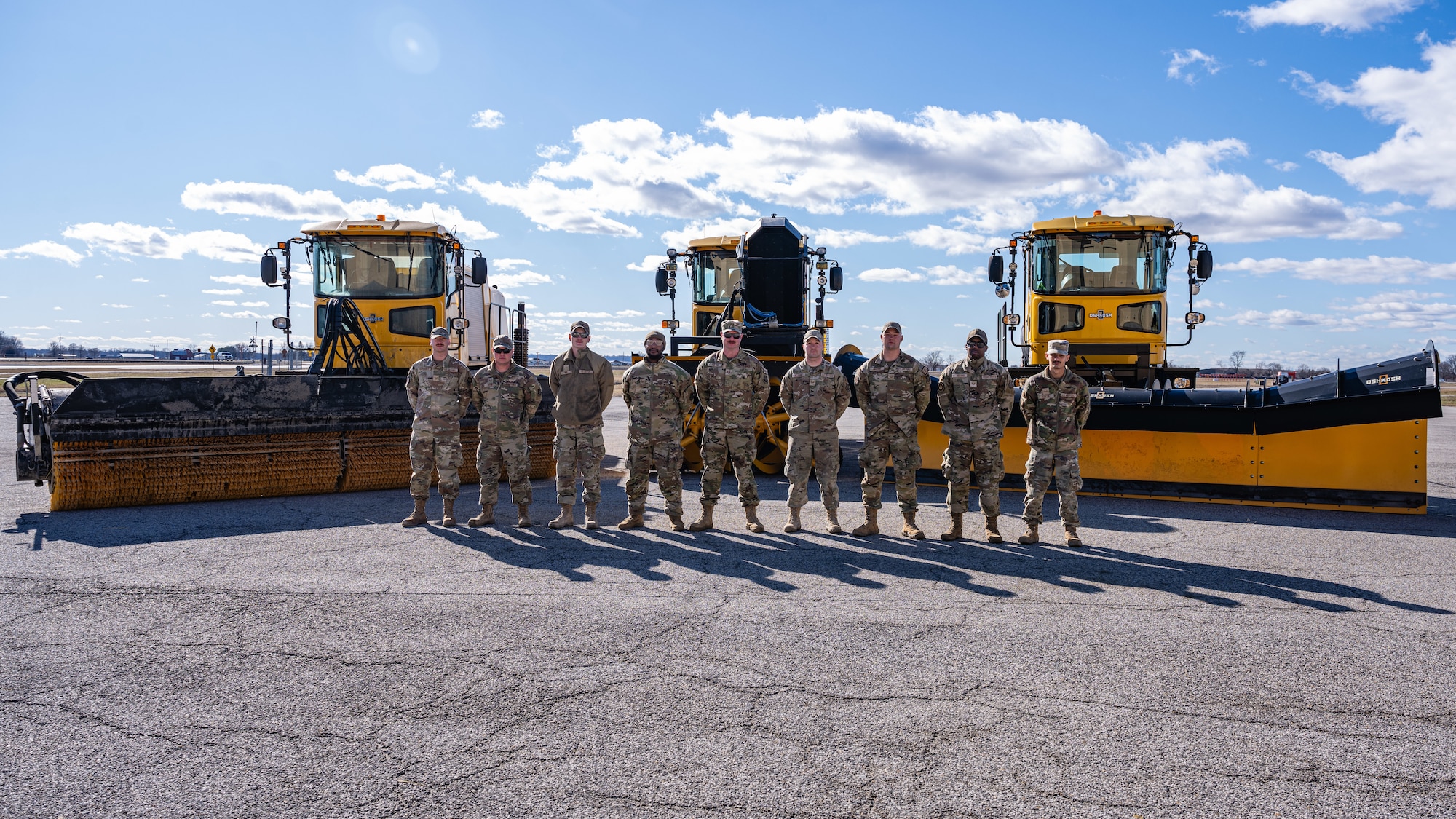 Airmen inspect snow removal equipment.