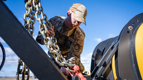 Airmen inspect snow removal equipment.