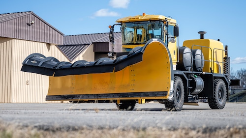 Airmen inspect snow removal equipment.