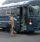 A U.S. Air Force Airman departs a bus on the flight line.
