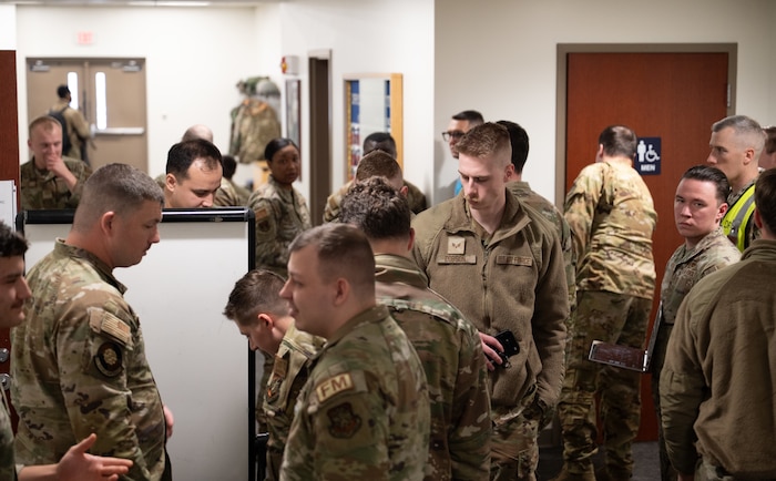 U.S. Air Force Airmen congregate before being processed through the personnel deployment function line.