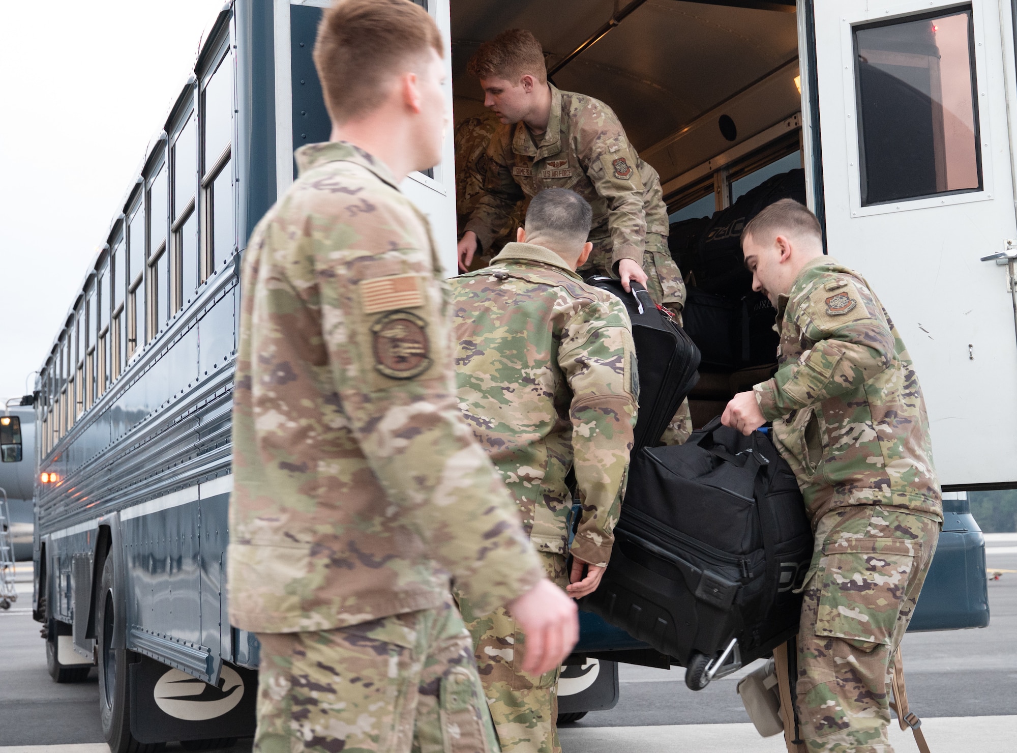 U.S. Air Force Airmen unload bags from a bus on the Joint Base Charleston flight line.