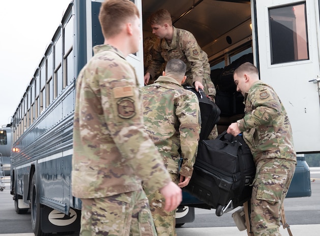 U.S. Air Force Airmen unload bags from a bus on the Joint Base Charleston flight line.