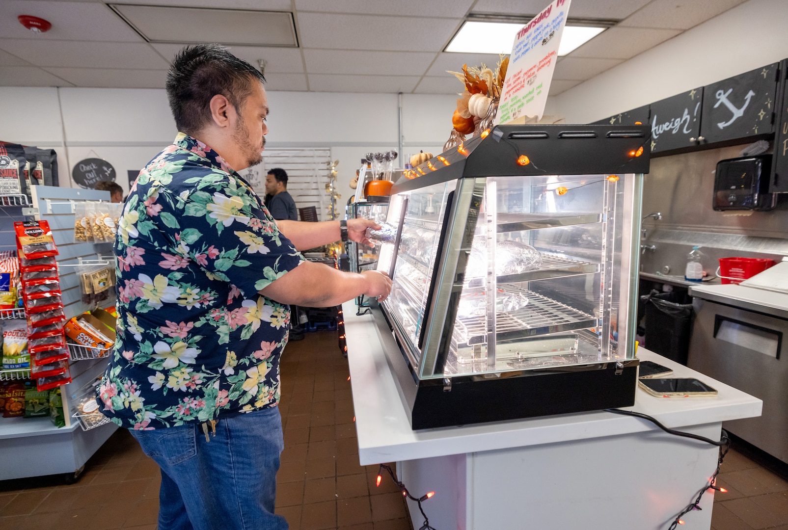 Ramon Gonzalez, branch head Code, 105.3Q, Radiological Control, Quality Assurance and Records Management Branch, grabs a hot sandwich at the Anchors Aweigh Building 850A location at Puget Sound Naval Shipyard & Intermediate Maintenance Facility in Bremerton Washington, Nov. 13, 2025. (U.S. Navy photo by Wendy Hallmark)
