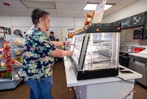 Ramon Gonzalez, branch head Code, 105.3Q, Radiological Control, Quality Assurance and Records Management Branch, grabs a hot sandwich at the Anchors Aweigh Building 850A location at Puget Sound Naval Shipyard & Intermediate Maintenance Facility in Bremerton Washington, Nov. 13, 2025. (U.S. Navy photo by Wendy Hallmark)