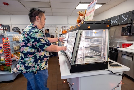 Ramon Gonzalez, branch head Code, 105.3Q, Radiological Control, Quality Assurance and Records Management Branch, grabs a hot sandwich at the Anchors Aweigh Building 850A location at Puget Sound Naval Shipyard & Intermediate Maintenance Facility in Bremerton Washington, Nov. 13, 2025. (U.S. Navy photo by Wendy Hallmark)