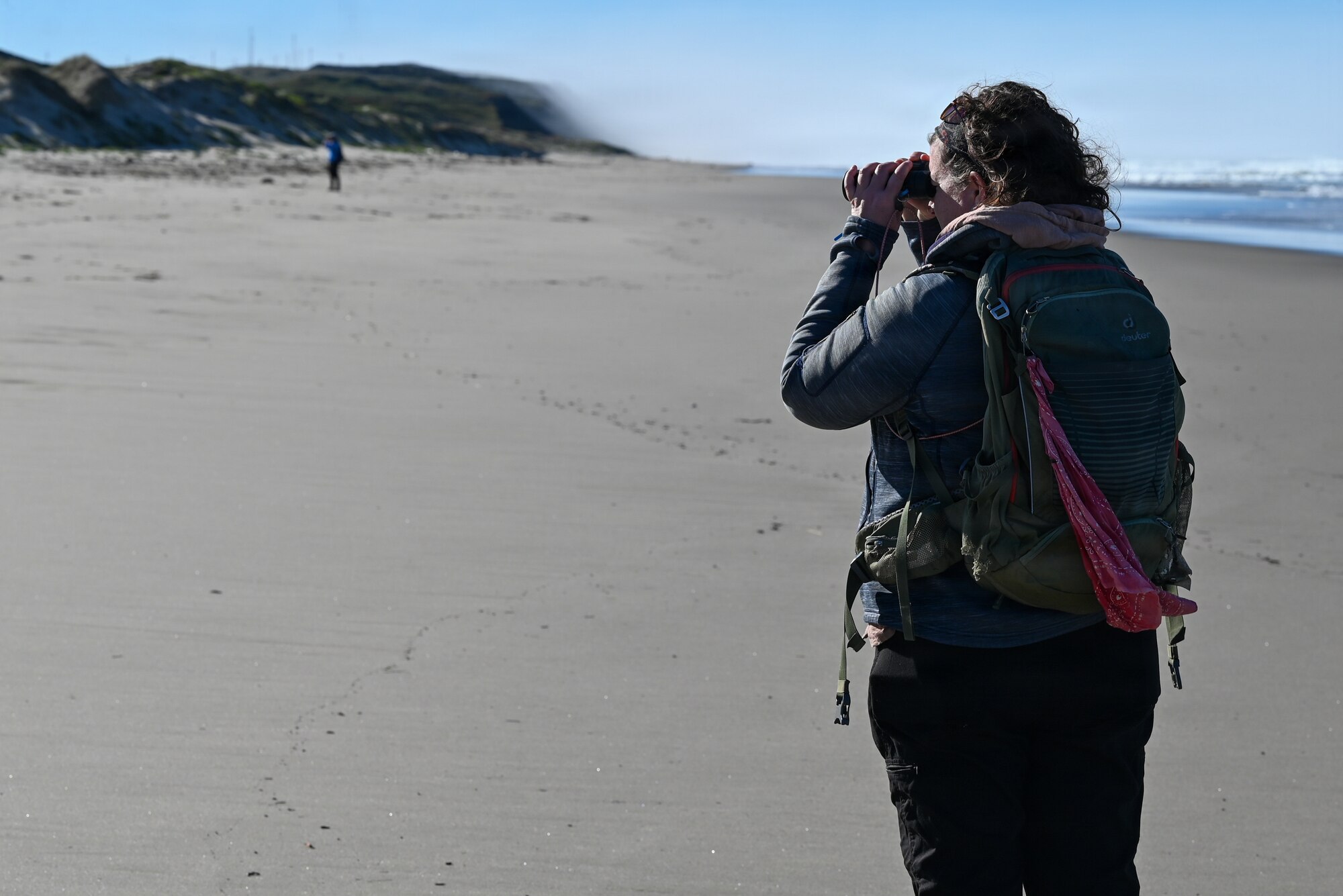 Emily Rice, Coastal Program Biologist with Point Blue Conservation Science, looks through her binoculars in search of Western Snowy Plovers.