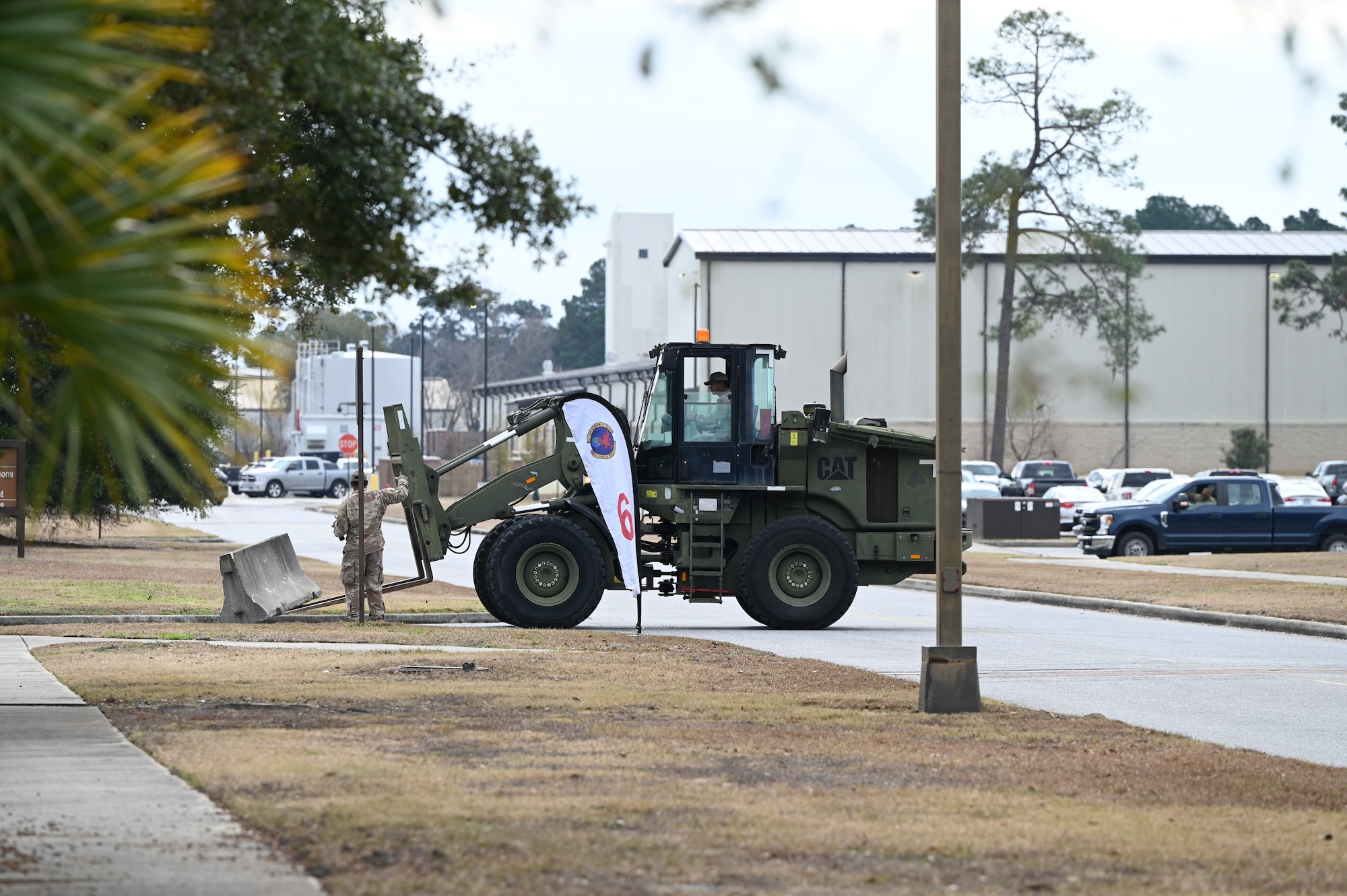 A 628th Civil Engineer Squadron Airman operates a forklift to deploy a concrete barrier.