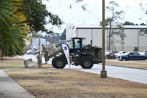 A 628th Civil Engineer Squadron Airman operates a forklift to deploy a concrete barrier.