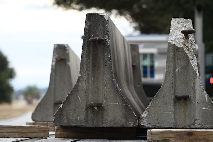 Concrete barriers sit atop the back of a semi-truck.