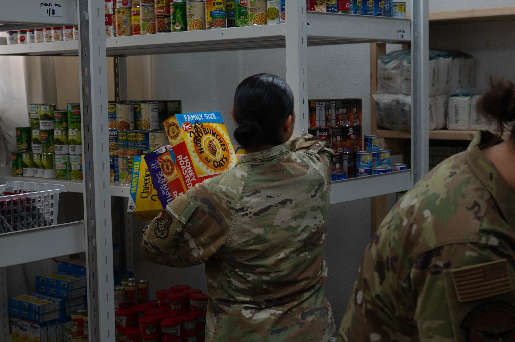 A woman stocks shelves full of food.
