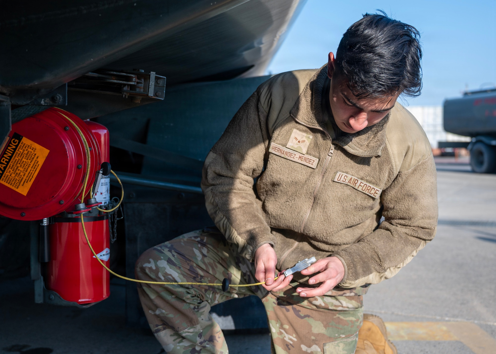 U.S. Air Force Airman 1st Class Jeffrey Hernandez-Mendez, 51st Logistics Readiness Squadron fuels maintenance technician, inspects a ground wire at Osan Air Base, Republic of Korea, Jan. 14, 2026. Hernandez-Mendez was selected to assist with preparing fuel trucks for shipment and inspection during a recent President of the United States visit. The task required draining, drying and certifying trucks before they were transported and later re-certified for aircraft fueling under Secret Service oversight. (U.S. Air Force photo by Staff Sgt. Sarah Williams)