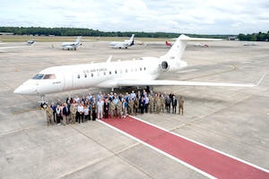 Group standing in front of plane