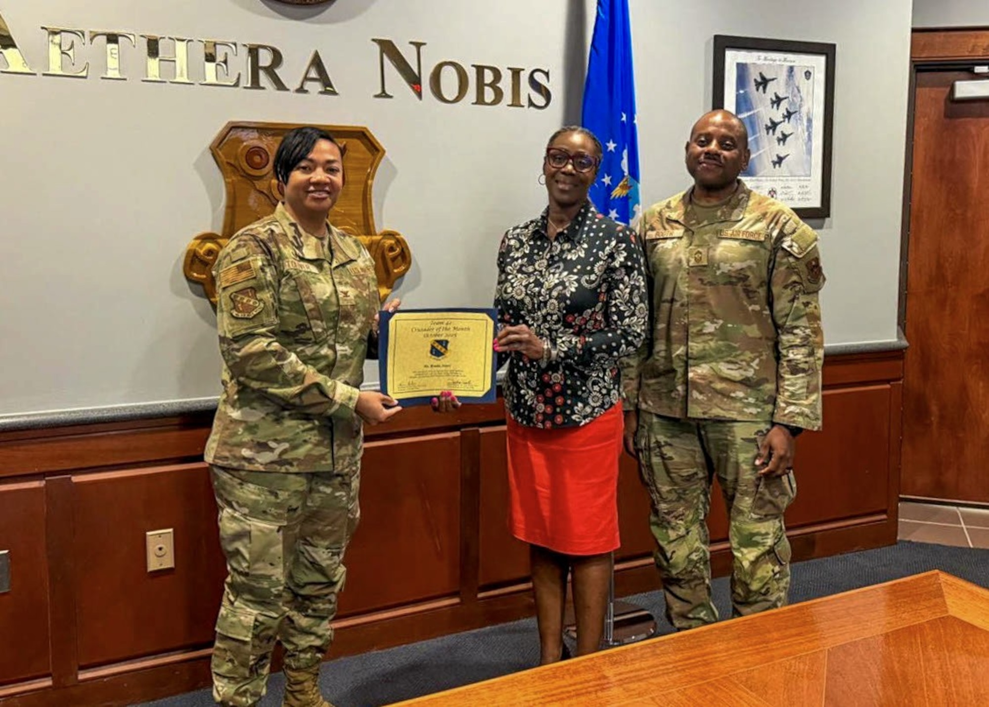 Tonyai Bonita Jones, 42d Force Support Squadron chief of child and youth services flight, receives the Crusader of the Month award for the month of October from Col. Shamekia Toliver, 42d Air Base Wing Commander, and Chief Master Sgt. Demetrius Booth, 42d ABW command chief, at Maxwell Air Force Base, Oct. 15, 2025.