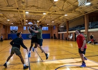 JBAB Airmen and staff play a game of half-court 3-on-3 basketball in a gymnasium.
