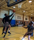 JBAB Airmen and staff play a game of half-court 3-on-3 basketball in a gymnasium.