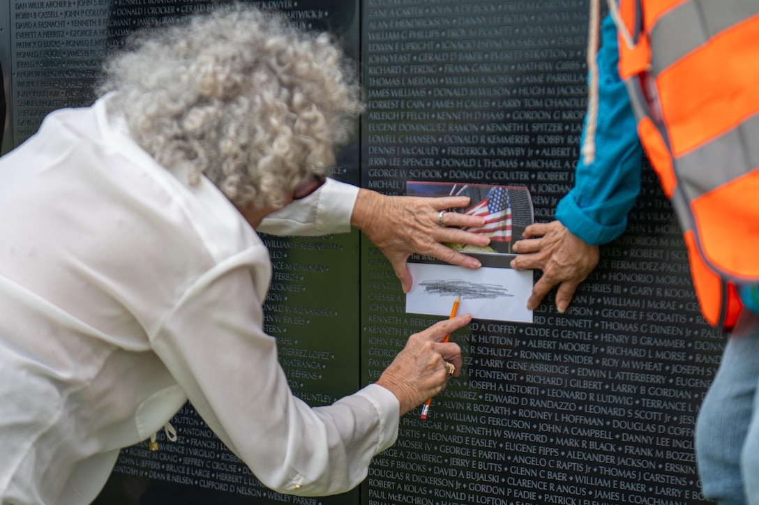 An attendee makes a name rubbing at The Wall That Heals Vietnam Veterans Memorial while assisted by a volunteer at the University of Hawaiʻi – West Oʻahu, Jan. 14.