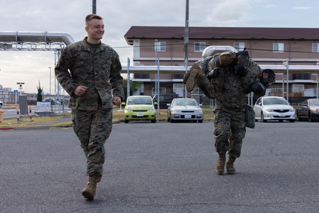 U.S. Marine Corps Lance Cpl. Christopher Benon, a chemical, biological, radiological, and nuclear (CBRN) specialist with Marine Wing Support Squadron (MWSS) 171, Marine Aircraft Group 12, 1st Marine Aircraft Wing, encourages Marines during CBRN training at Marine Corps Air Station Iwakuni, Japan, Nov. 24, 2025. CBRN training is crucial for Marines to remain capable, confident and operation ready in any environment. (U.S. Marine Corps photo by Lance Cpl. Ella Cadby)