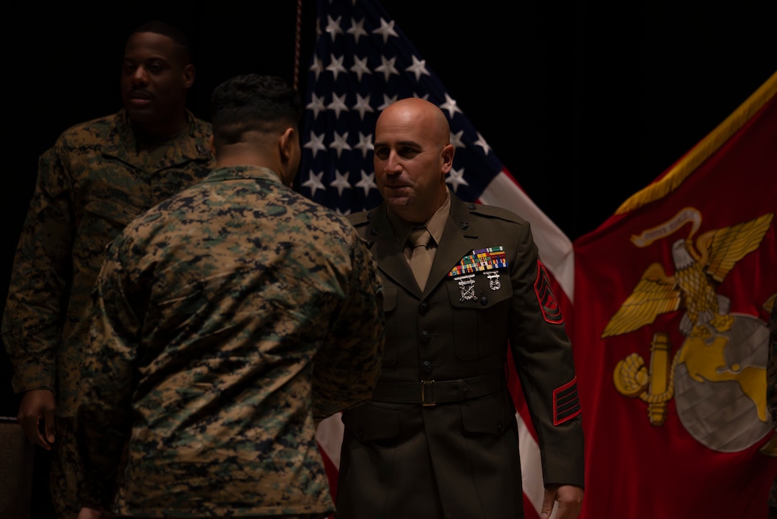 U.S. Marine Corps Gunnery Sgt. Robert Navarro, the officer in charge of the indoor small arms range with Headquarters and Headquarters Squadron, Marine Corps Air Station, and native to Oceanside, California, shakes hand with a Marine during the Gunnery Sgt. Carlos N. Hathcock II award ceremony at MCAS Iwakuni, Japan, Nov. 4, 2025. Gunnery Sgt. Navarro was awarded the Gunnery Sgt. Carlos N. Hathcock II award for his prestigious work and dedication to improving marksmanship of the ISAR and efficiently training rifle and pistol qualifications. (U.S. Marine Corps photo by Lance Cpl. Isaac De Leon)