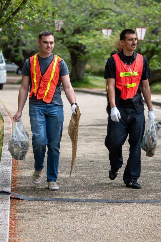 U.S. Marine Corps Lance Cpl. Aidan Montalvo, left, a native of California, and Cpl. Nicholas Brooks, a native of Nevada, both expeditionary firefighting and rescue specialists with Aircraft Rescue and Firefighting, Headquarters and Headquarters Squadron, Marine Corps Air Station Iwakuni, carry collected trash during a clean-up at the Kintaikyo Bridge, Iwakuni, Japan, April 21, 2025. The Marine Corps Community Services Iwakuni, Single Marine Program hosted a bridge clean-up as part of the SMP Days of Service, a five-day series of events where service members from Marine Corps Air Station Iwakuni volunteer to build stronger relationships and give back to the community. (U.S. Marine Corps photo by Sgt. Randall Whiteman)