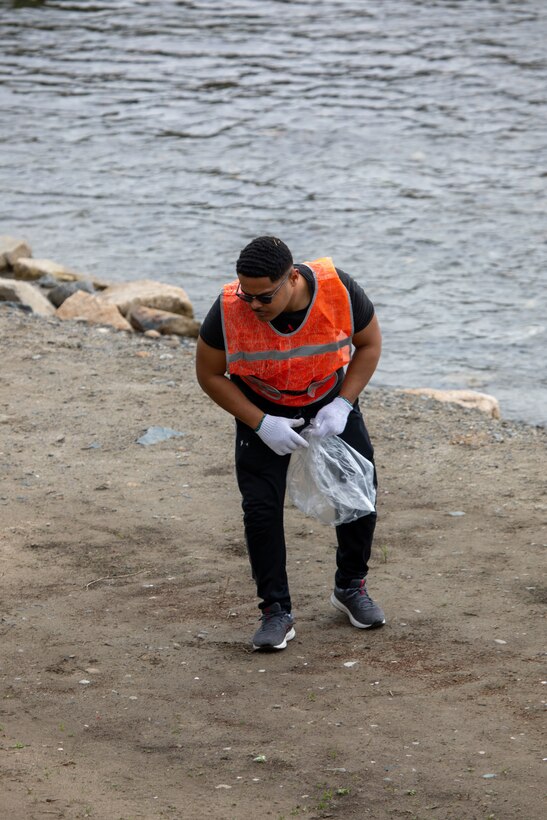 U.S. Marine Corps Lance Cpl. Jacob Fogel, a training non-commissioned officer with Combat Logistics Company 36, 3rd Sustainment Group Experimental, 3rd Marine Logistics Group, and a native of Michigan, picks up trash alongside the riverbank during a clean-up at the Kintaikyo Bridge, Iwakuni, Japan, April 21, 2025. The Marine Corps Community Services Iwakuni, Single Marine Program hosted a bridge clean-up as part of the SMP Days of Service, a five-day series of events where service members from Marine Corps Air Station Iwakuni volunteer to build stronger relationships and give back to the community. (U.S. Marine Corps photo by Sgt. Randall Whiteman)