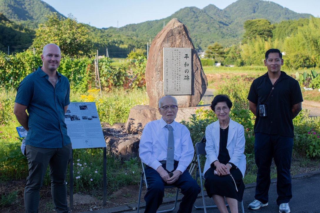 From left to right, U.S. Marine Corps Maj. Mason Englehart, communication strategy and operations director, Headquarters and Headquarters squadron (H&HS), Marine Corps Air Station Iwakuni, Shigeaki Mori, a Japanese historian and a survivor of the atomic bombing of Hiroshima, Kayoko Mori, the wife of Mr. Mori, and Gunnery Sgt. Miguel Rosales, communication strategy operations chief, H&HS, MCAS Iwakuni, pose for a group photo during a memorial event, Yanai, Japan, July 28, 2025. Local residents came together to support the memorial in Yanai, Japan, paying tribute to American and Japanese lives lost during World War II. (U.S. Marine Corps photo by Lance Cpl. Micah Taylor)