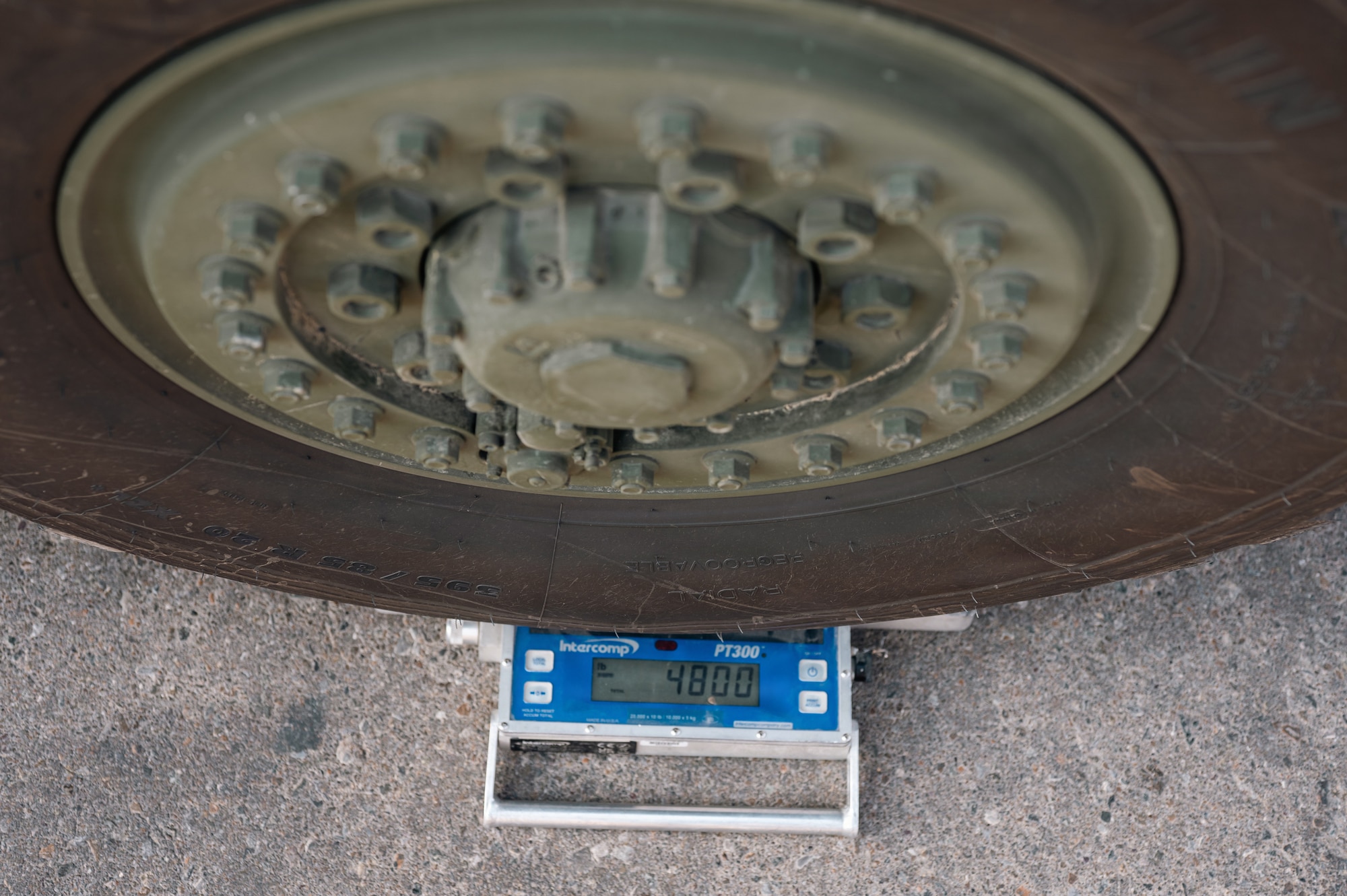 People stand around military vehicle
