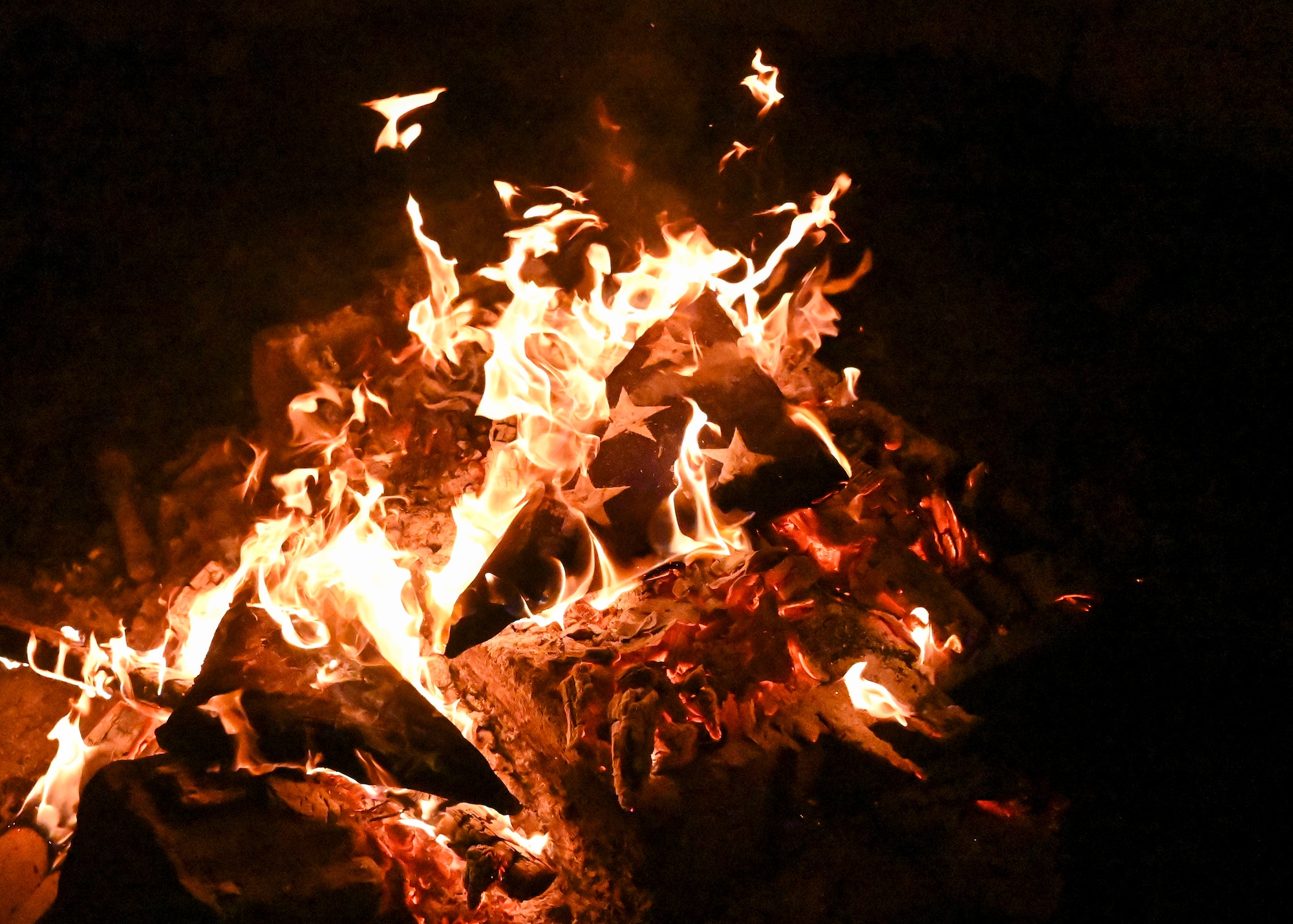 A American flag burns in a fire pit.
