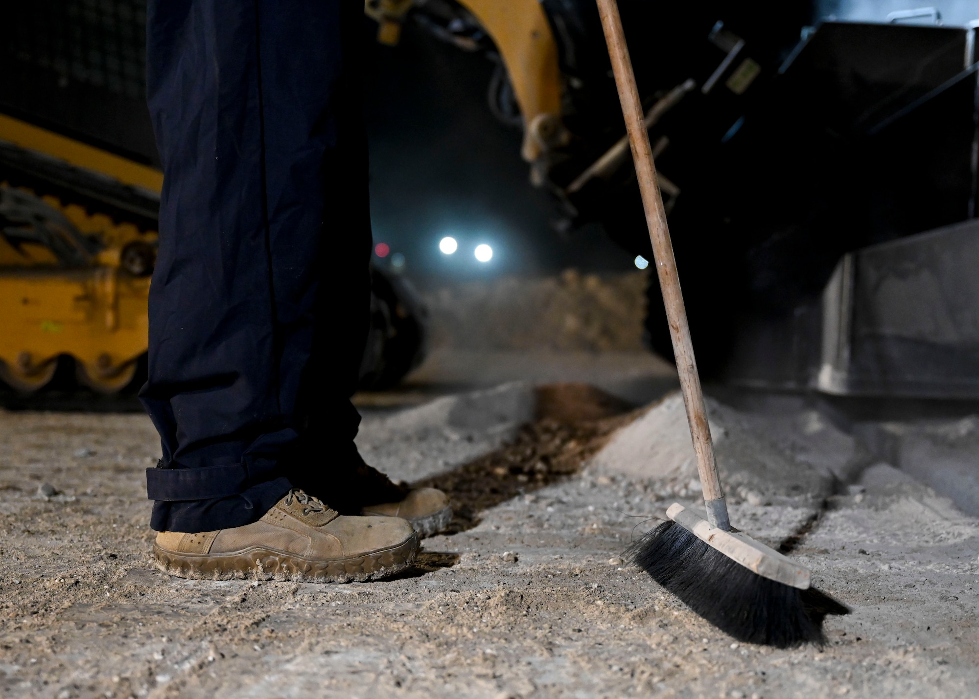 A man holds a broom.