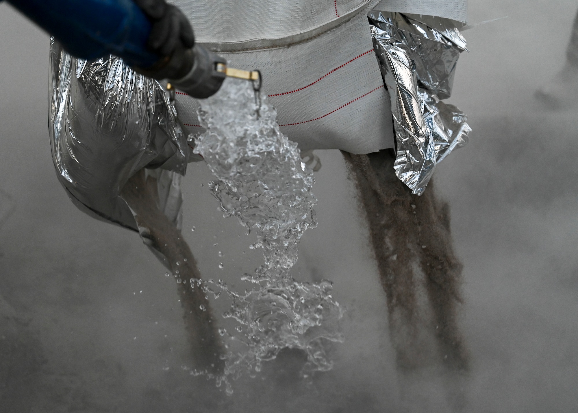 A hose pumps out water to mix with cement.
