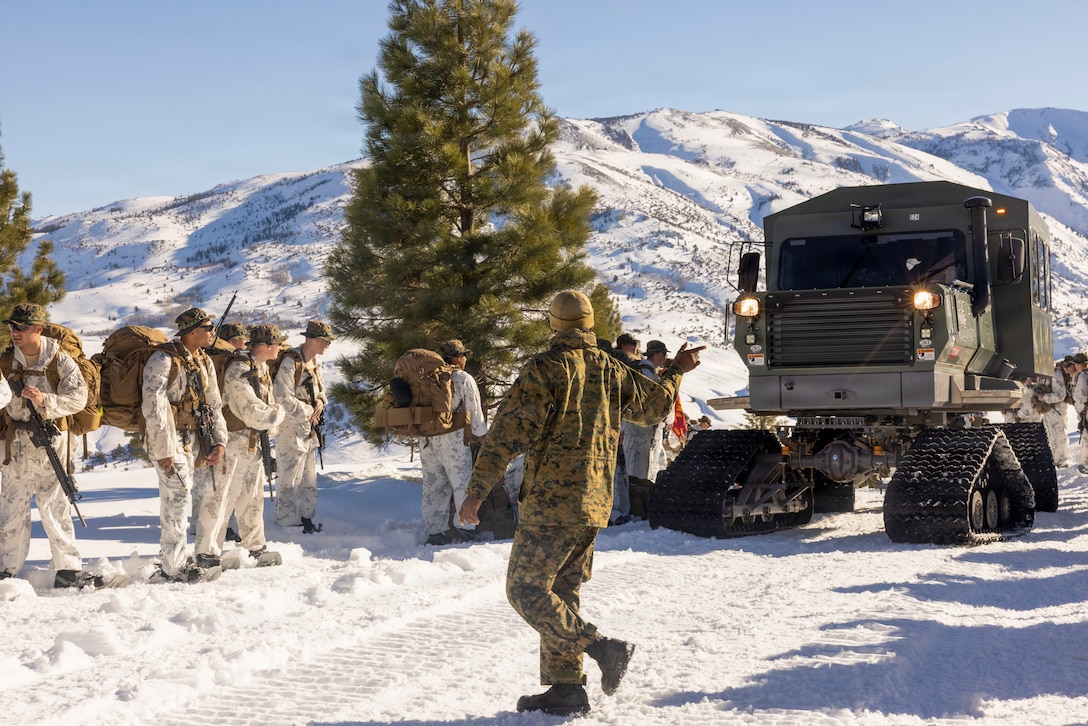 U.S. Marines and Sailors with Combat Logistics Battalion 24, Combat Logistics Regiment 27, 2nd Marine Logistics Group, come to a halt to allow a Tucker terra model 1600 sno-cat, assigned to Marine Corps Mountain Warfare Training Center, to pass by during an acclimation hike as part of Mountain Training Exercise 1-26 at Marine Corps Mountain Warfare Training Center in Bridgeport, California, Jan. 14, 2026. CLB-24 executed the acclimation hike to familiarize the Marines with hiking in austere terrain and high elevations. Exercises like MTX 1-26 prove Marines’ ability to provide flexible and responsive combat service support during high intensity combat operations in contested and mountainous terrain. (U.S. Marine Corps photo by Lance Cpl. Isabella Ramos)